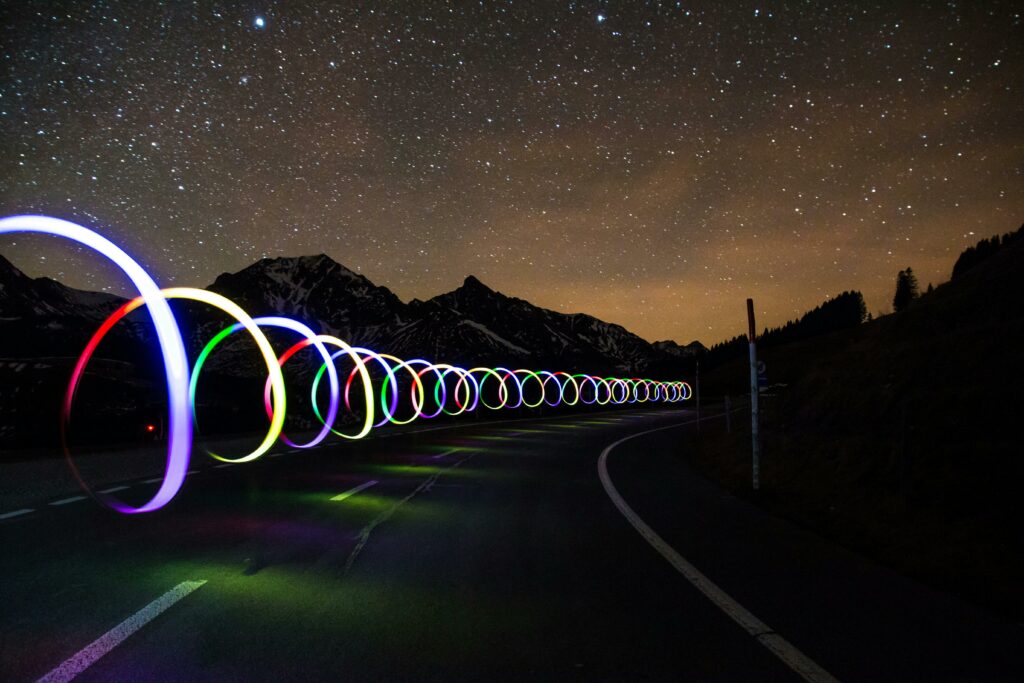 pexels-photo-290470-290470 Octopoda Solutions- Enchanting long exposure of colorful light trails on a winding road beneath a star-filled sky.